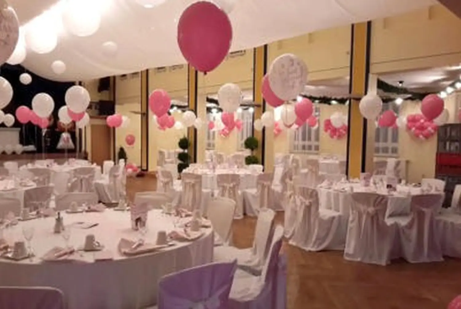 Ballon Moments - Dekoration - Festsaal mit pink-weißen Luftballons über runden Tischen