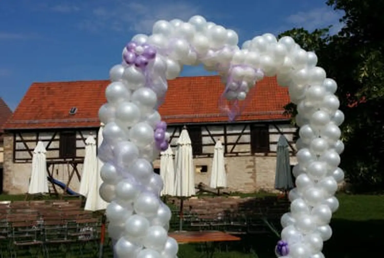 Ballon Moments - Dekoration - Weißer Ballonbogen vor Fachwerkhaus