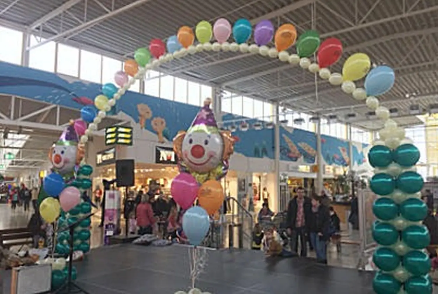 Ballon Moments - Dekoration -Bunter Ballonbogen mit Clown-Folienballon im Einkaufszentrum