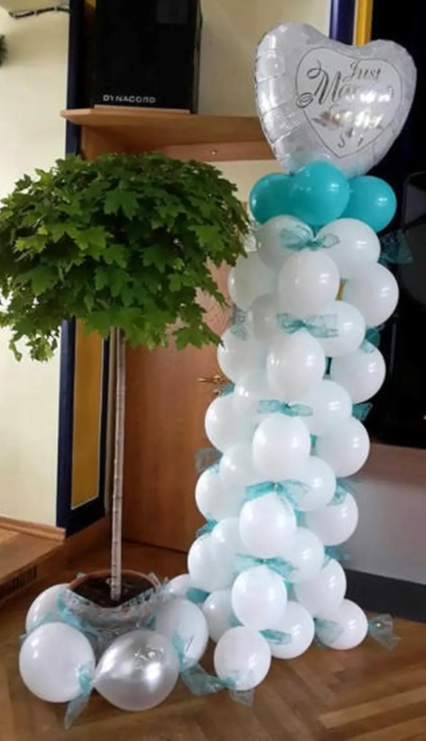 Ballon Moments - Dekoration - Weiß-türkise Ballonsäule neben Pflanze