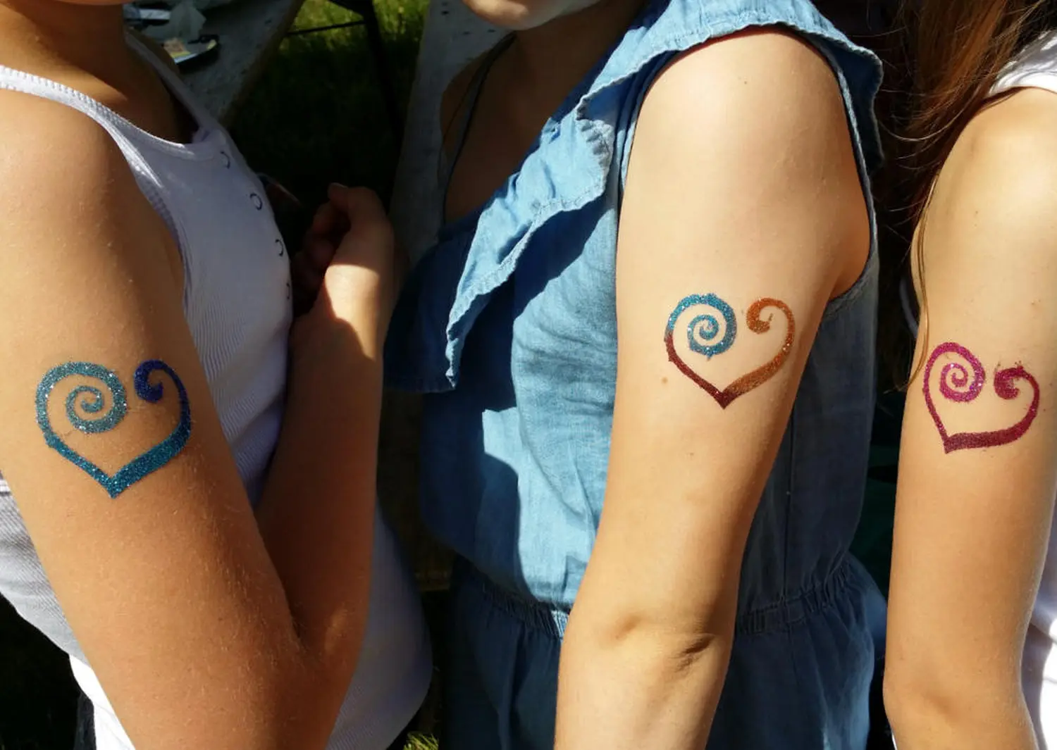 Moments Veranstaltungsagentur - Glitzertattoos in Herzform am Arm