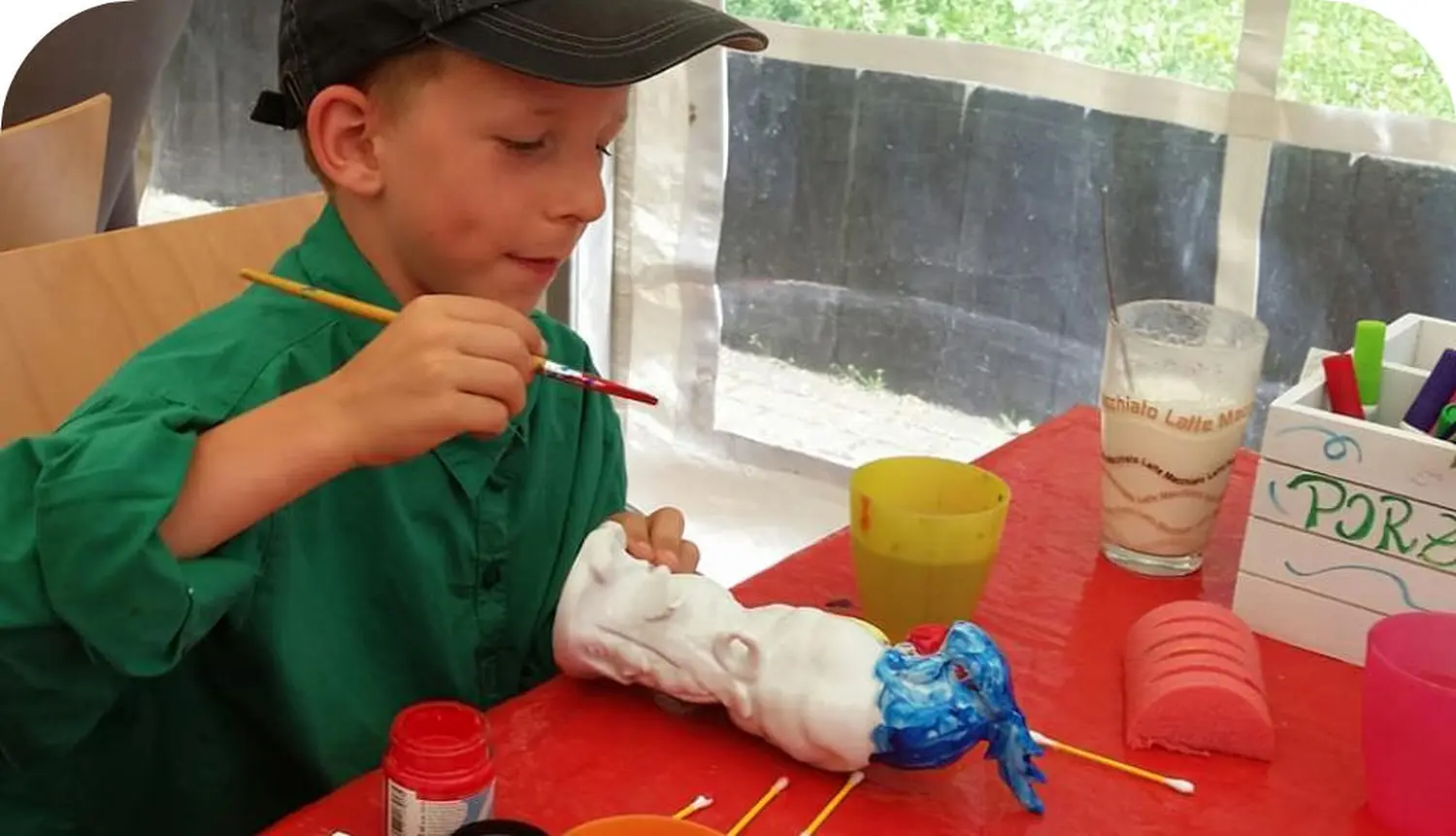 Moments Veranstaltungsagentur -  Junge bemalt Porzellanfigur mit Pinsel