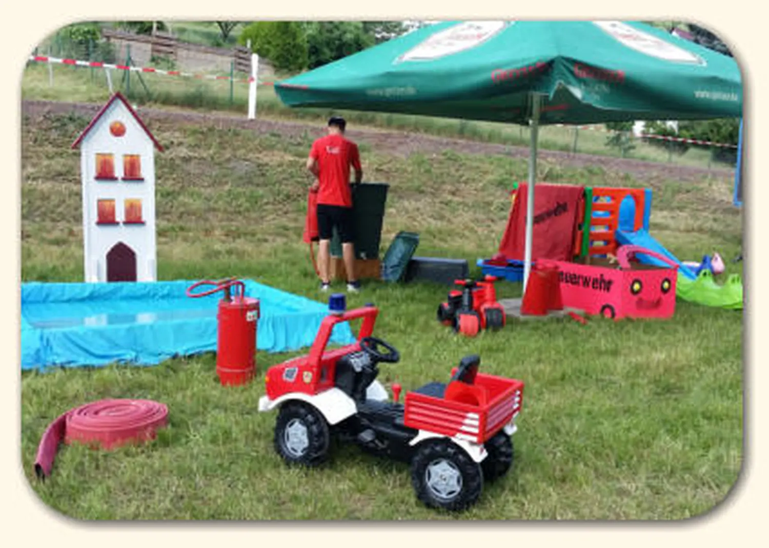 Moments Veranstaltungsagentur -Feuerwehr-Spielzeugauto und Pavillon auf einer Wiese