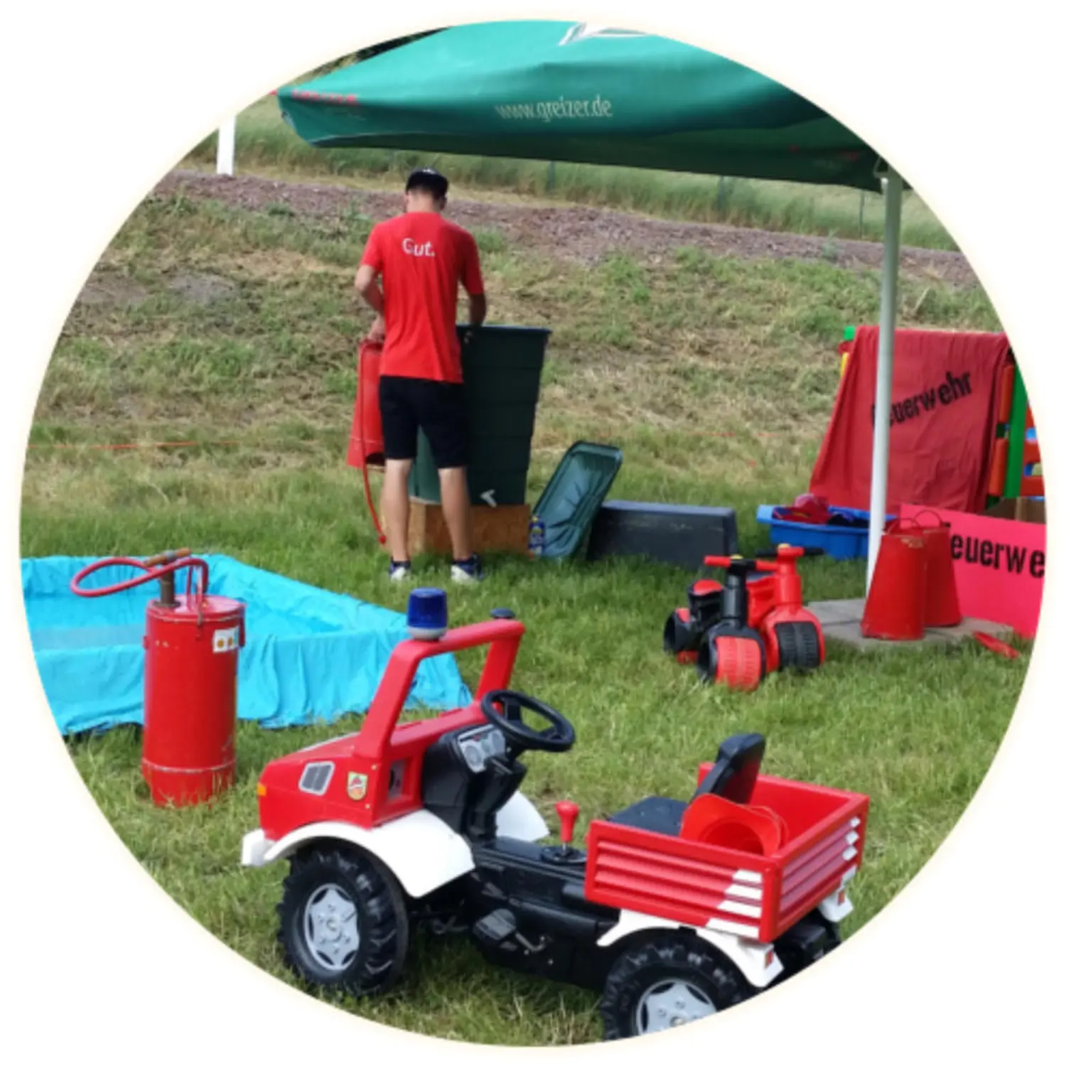 Moments Veranstaltungsagentur - Feuerwehr-Spielzeugauto und Pavillon auf einer Wiese