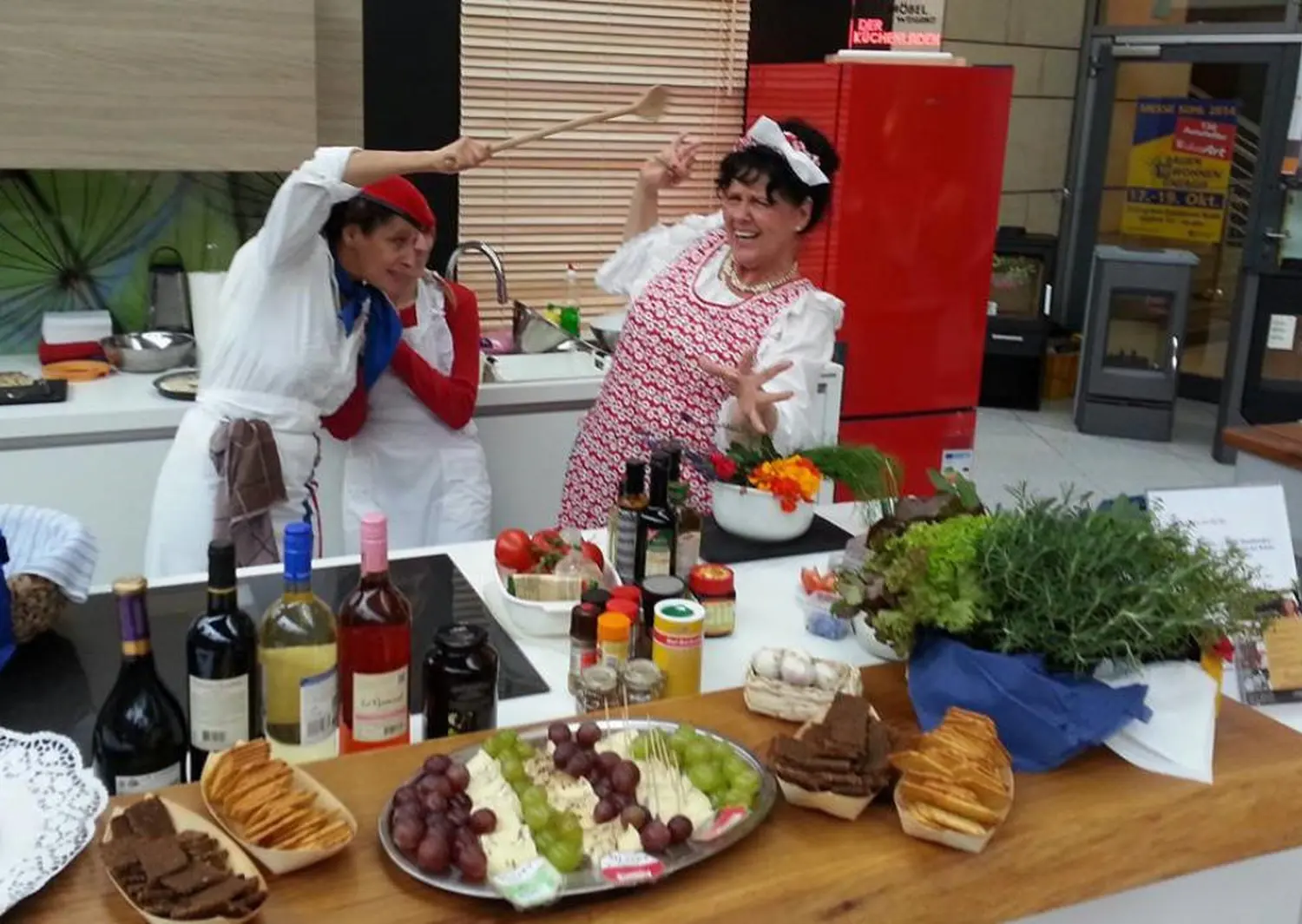 Moments Veranstaltungsagentur - Zwei Frauen kochen ausgelassen mit Kochlöffel