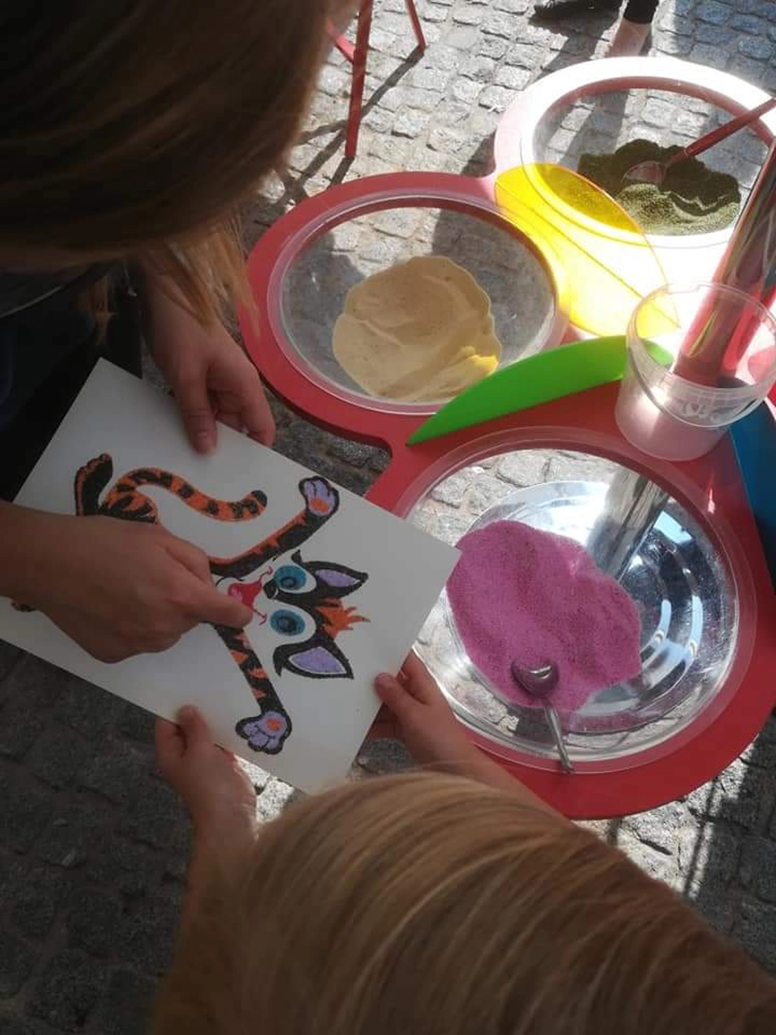 Moments Veranstaltungsagentur - Kinder gestalten Tigermotiv mit Sand