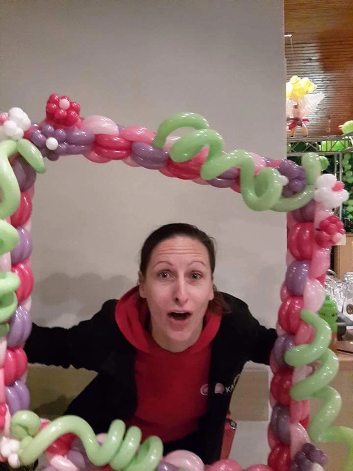 Moments Veranstaltungsagentur - Frau im Ballonrahmen mit Blumendeko