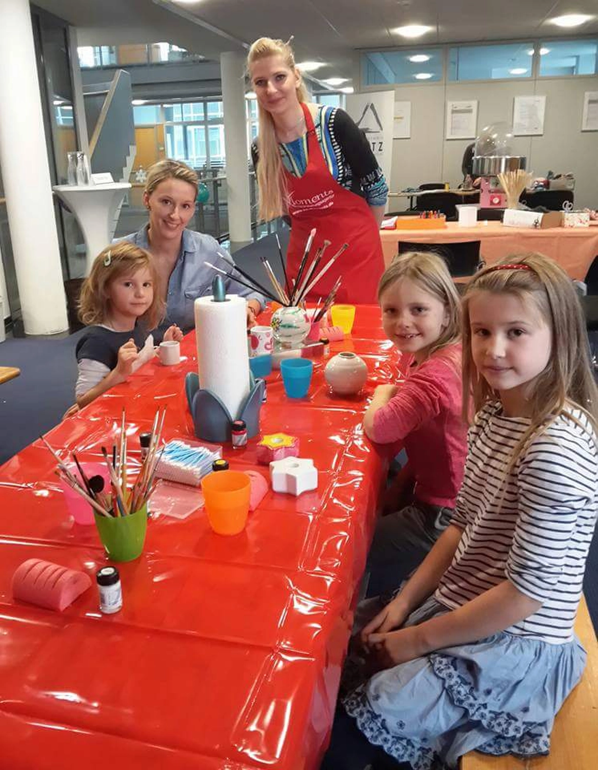 Moments Veranstaltungsagentur - Familie beim Porzellanmalen am Tisch