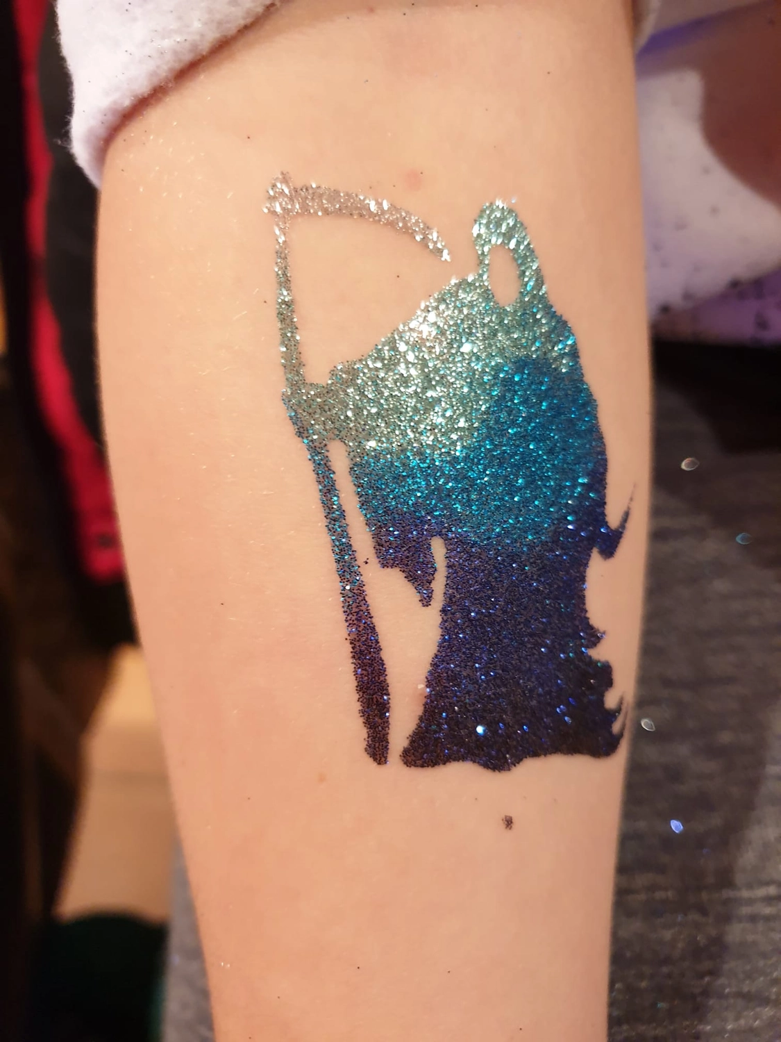 Moments Veranstaltungsagentur - Glitzertattoo Sensenmann in Blau