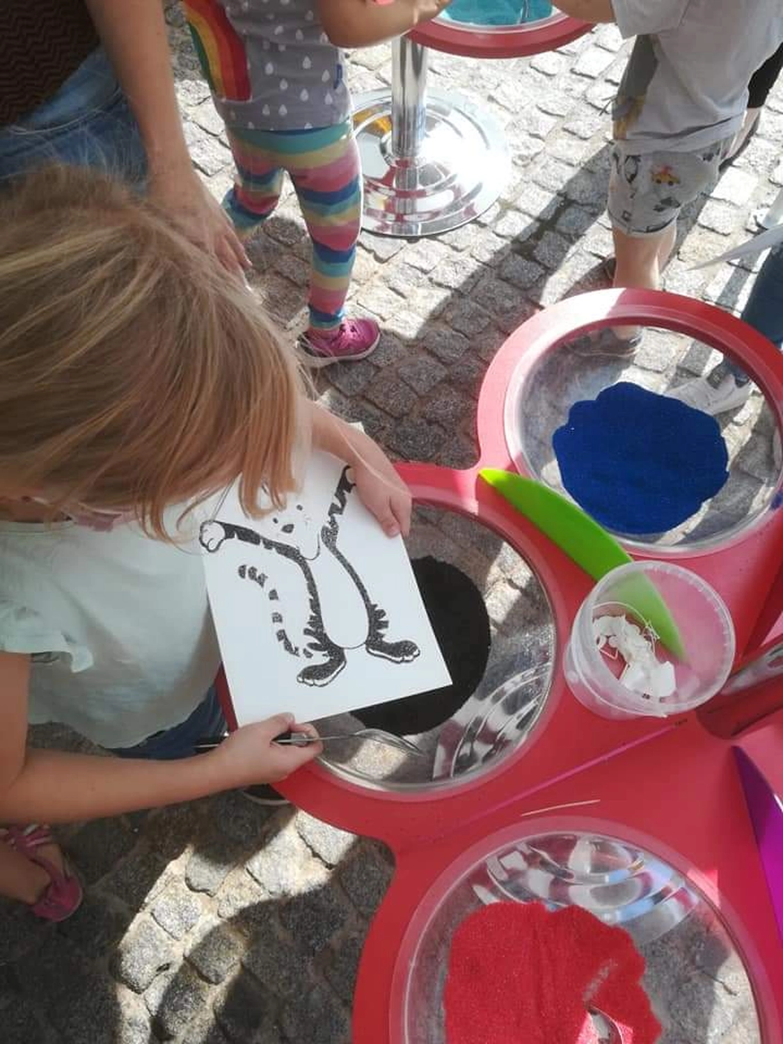 Moments Veranstaltungsagentur - Kind gestaltet Sandbild am Stand