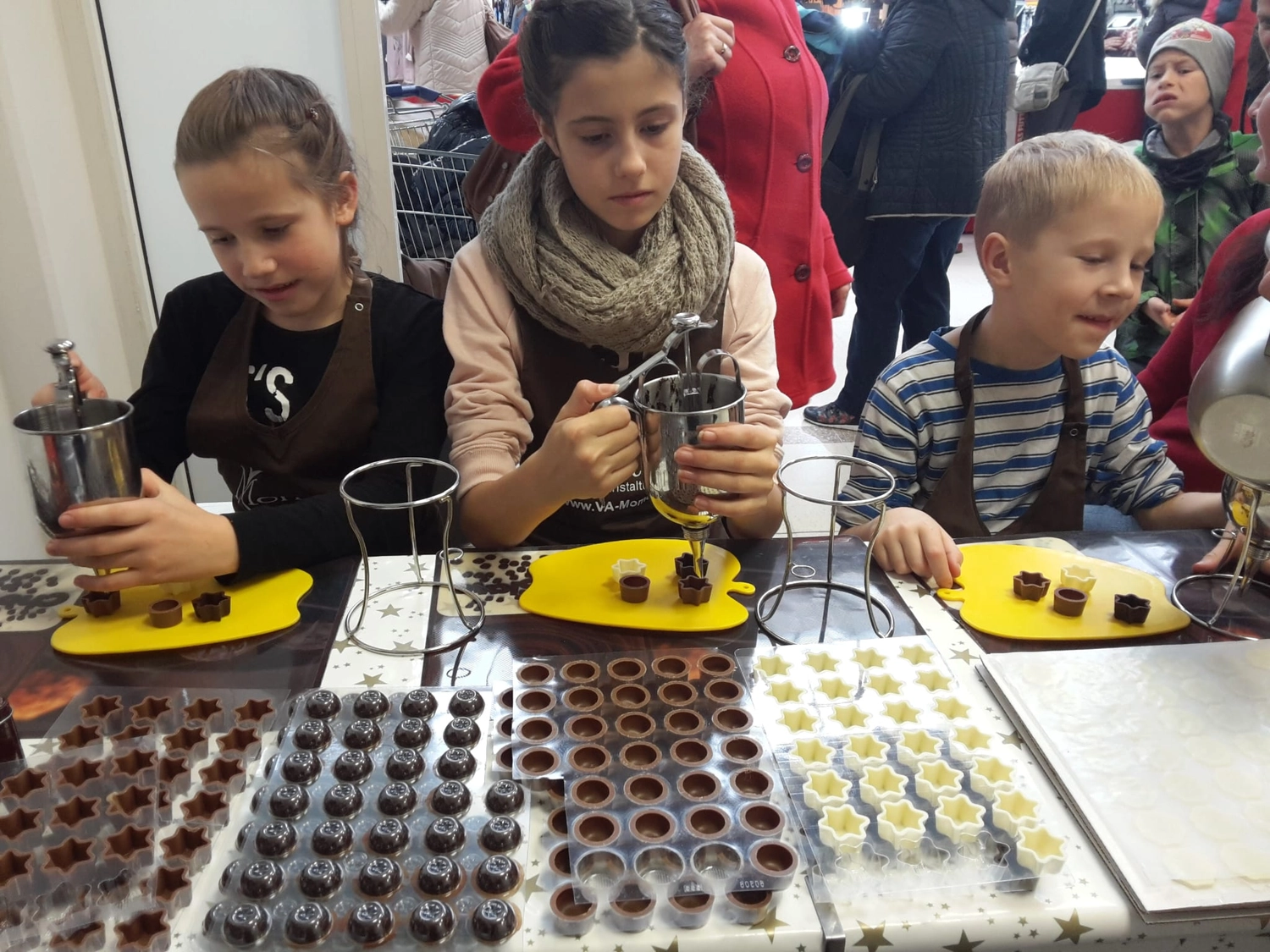 Moments Veranstaltungsagentur - Kinder befüllen Schokoladenförmchen